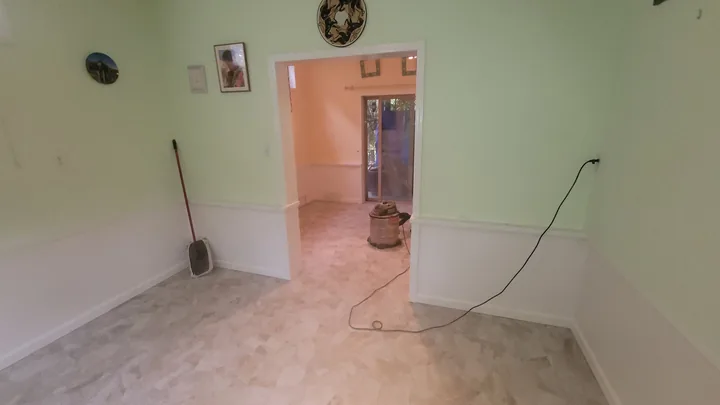 Natural stone tile floor meeting painted walls and white trim in the office.