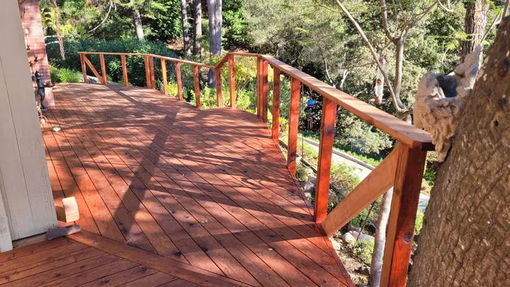 Stained posts and a continuous top rail following the deck edge before the cables are installed.