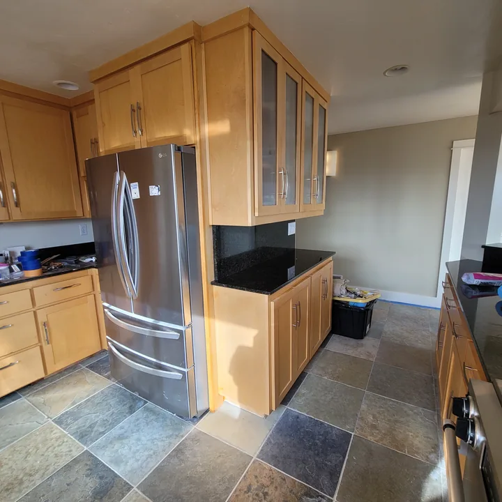 Kitchen with appliances, cabinets, and flooring in place while countertop repairs remain in progress.