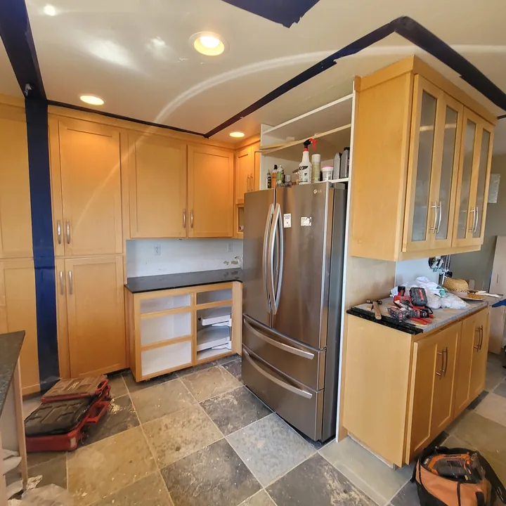 Installed slate floor and cabinetry with the backsplash and wall finishes still in progress.