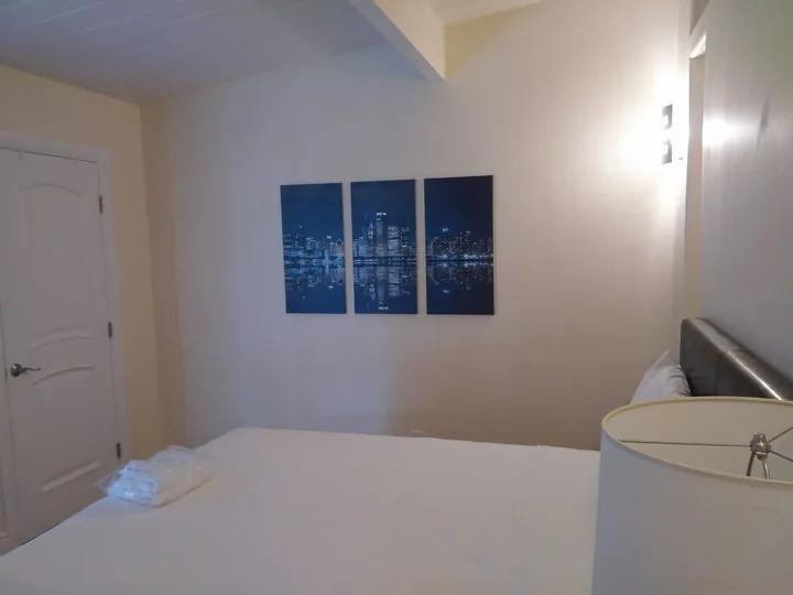 Three vertical blue cityscape works arranged in a row on a bedroom wall.