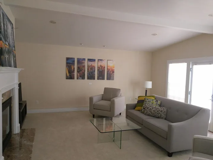 A row of cityscape artworks hung above living-room seating.
