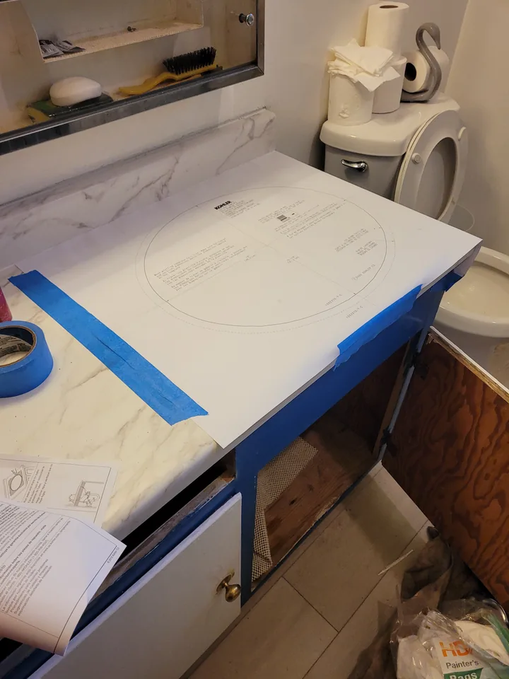 A paper sink template secured to the new countertop with blue tape.
