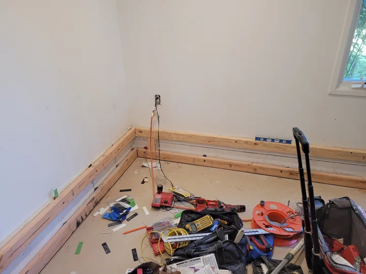 Work in progress on the timber casing around the existing curb at a corner of the room.